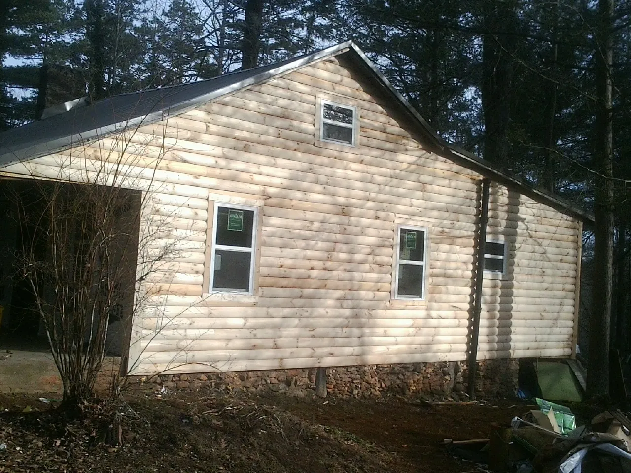 New log siding and dark metal roofing on a gable end in Davenport